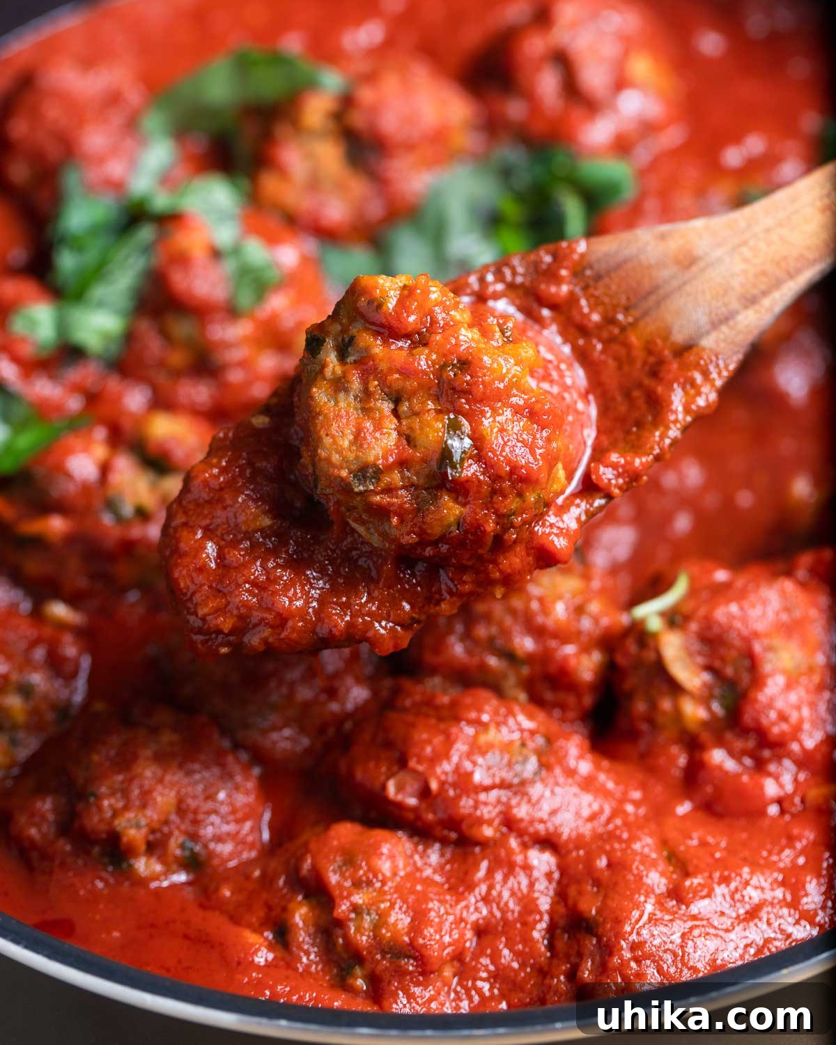 Flavorful Italian Sausage Meatballs 2 Sausage meatball held with wooden spoon.