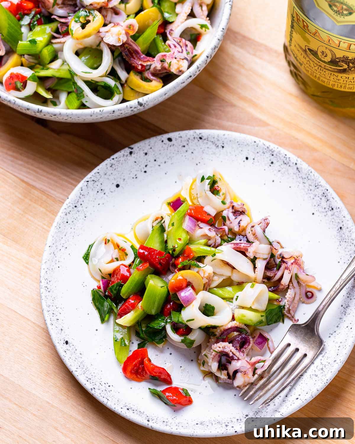 Zesty Italian Calamari Salad 8 White plate with Italian calamari salad and fork.