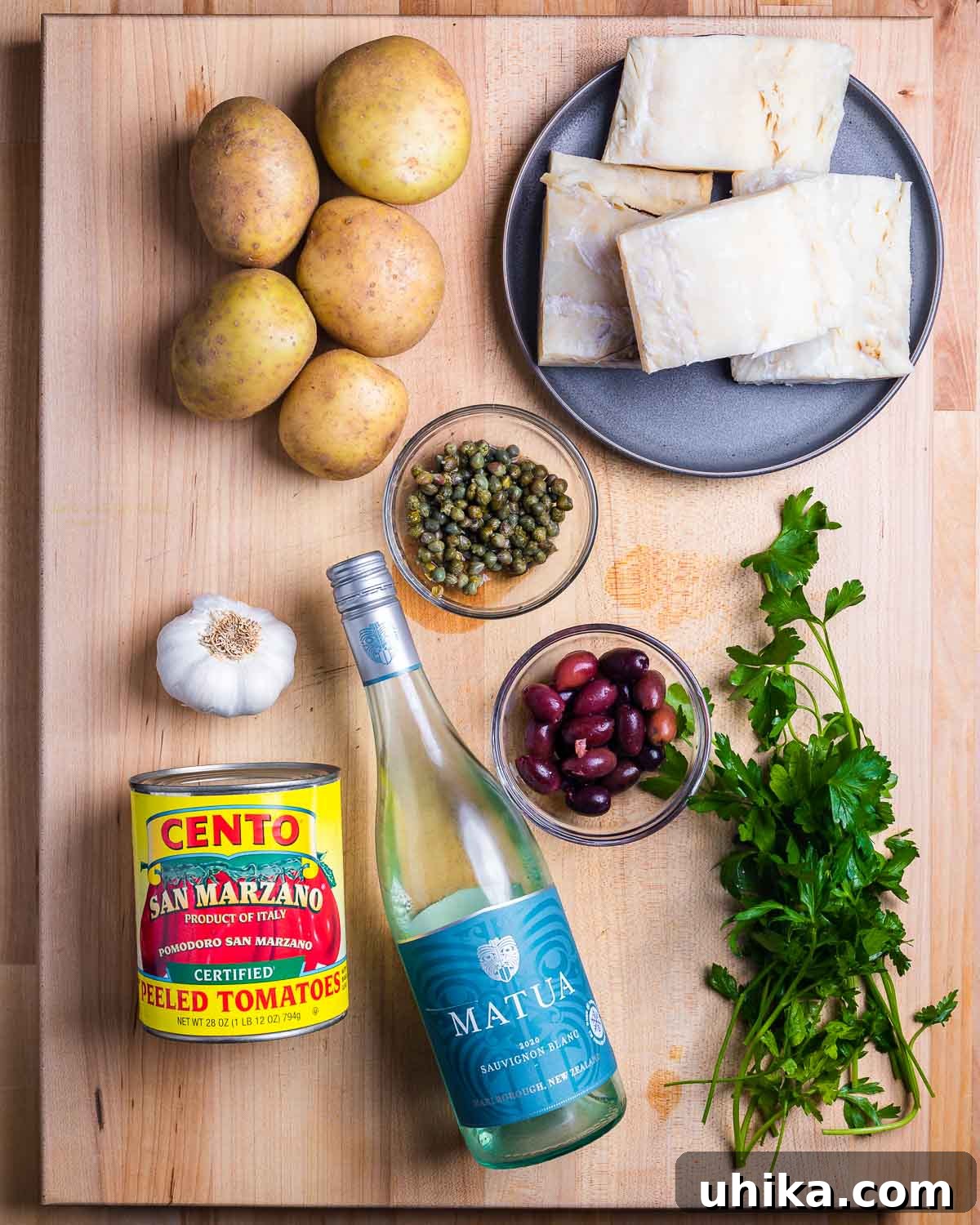 Naples' Signature Baccala 3 Fresh ingredients laid out for Baccala alla Napoletana: potatoes, salt cod, capers, garlic, plum tomatoes, white wine, olives, and fresh parsley.