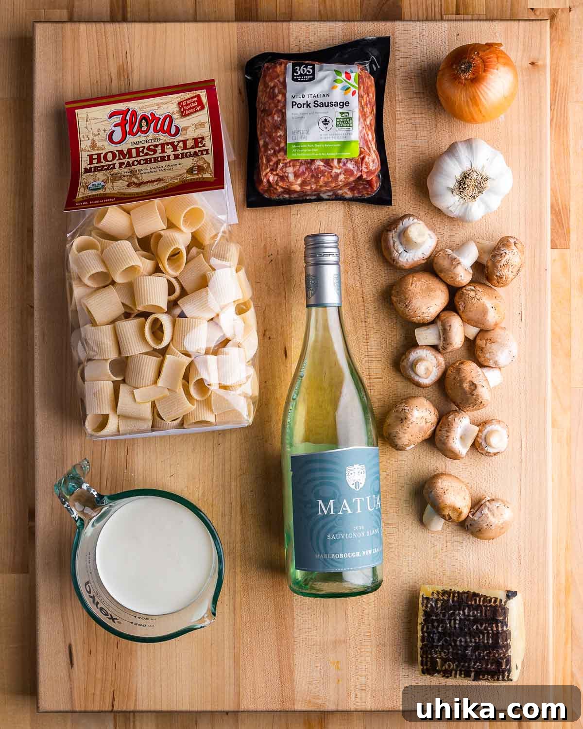 Norcia Sausage Pasta 3 Ingredients for Pasta alla Norcina laid out: paccheri pasta, sausage, onion, garlic, mushrooms, cream, white wine, and Pecorino Romano.
