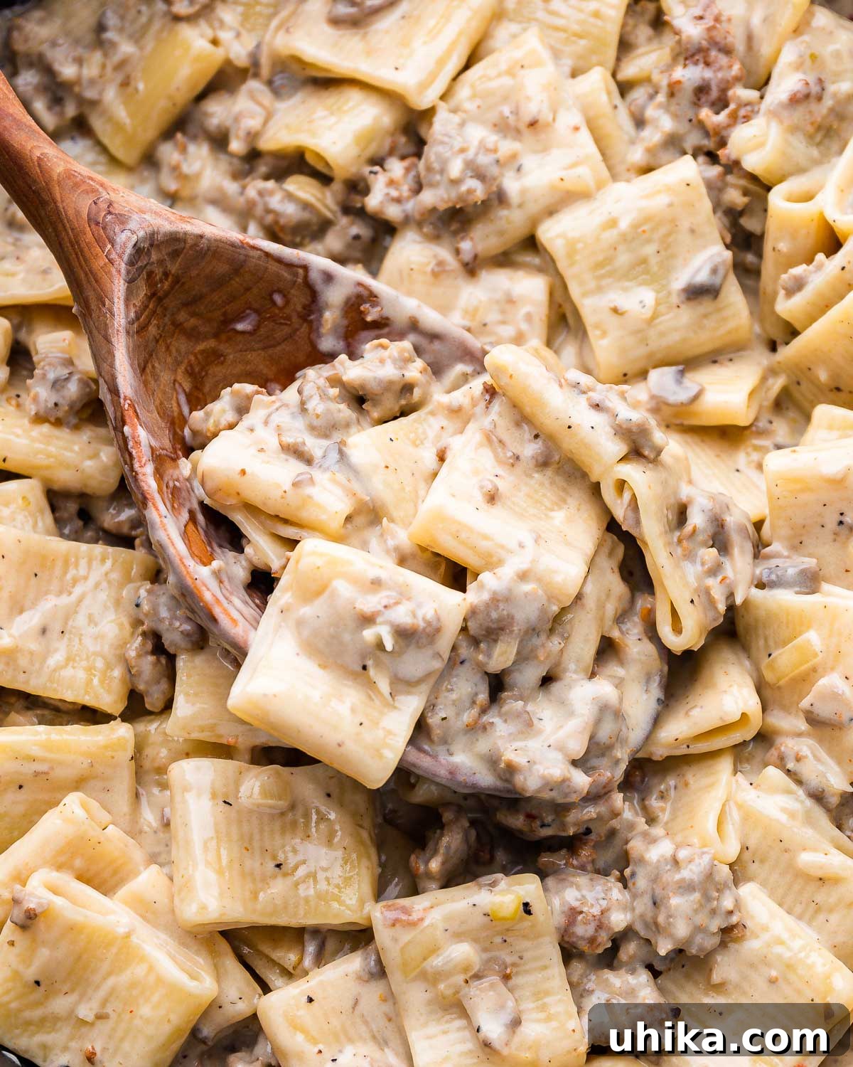 Norcia Sausage Pasta 7 Large wooden spoon lifting paccheri alla norcina from the pan.