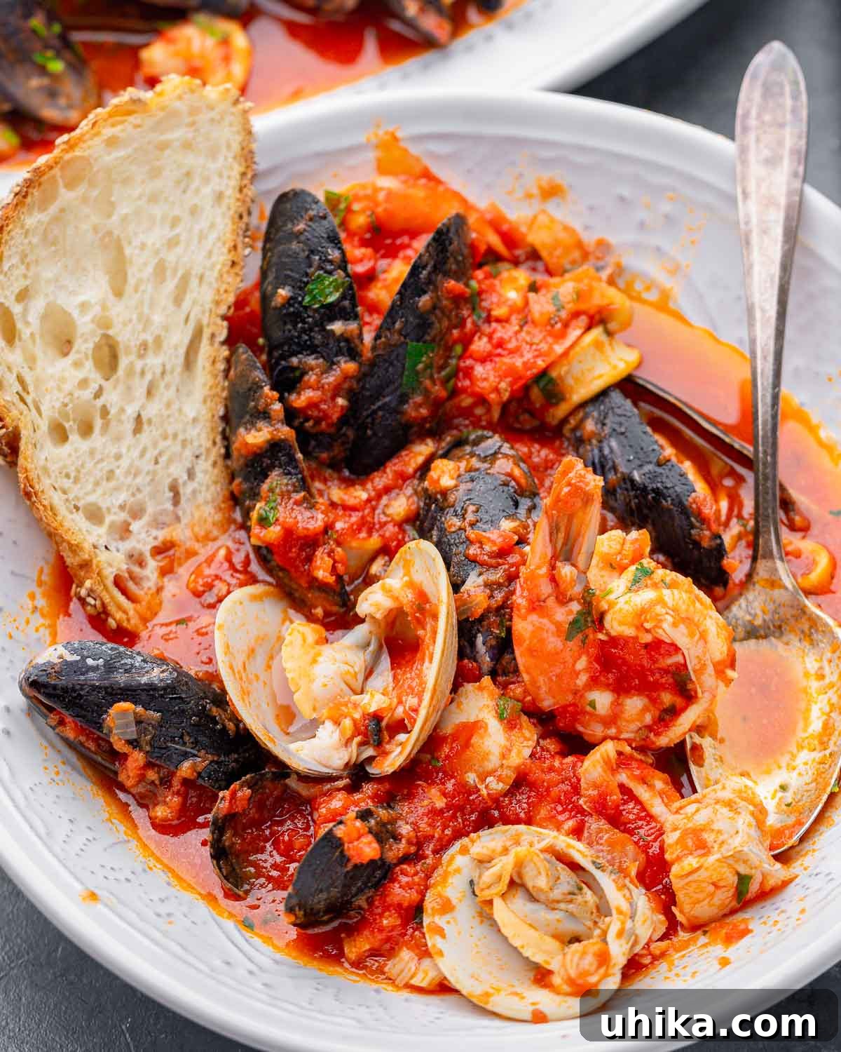 Hearty Italian Seafood Stew 10 Zuppa di pesce in white bowl with toasted bread.