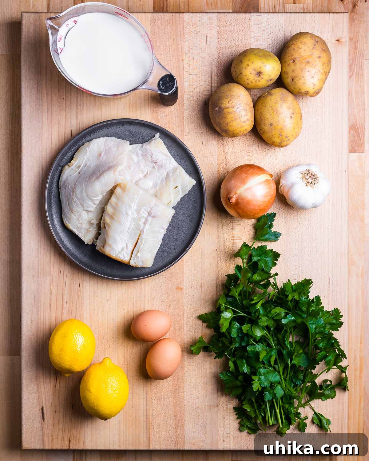 Mediterranean Salt Cod Fritters 3 All ingredients for baccala fritters displayed: milk, potatoes, baccala (salt cod), onion, garlic, lemons, eggs, and fresh parsley.