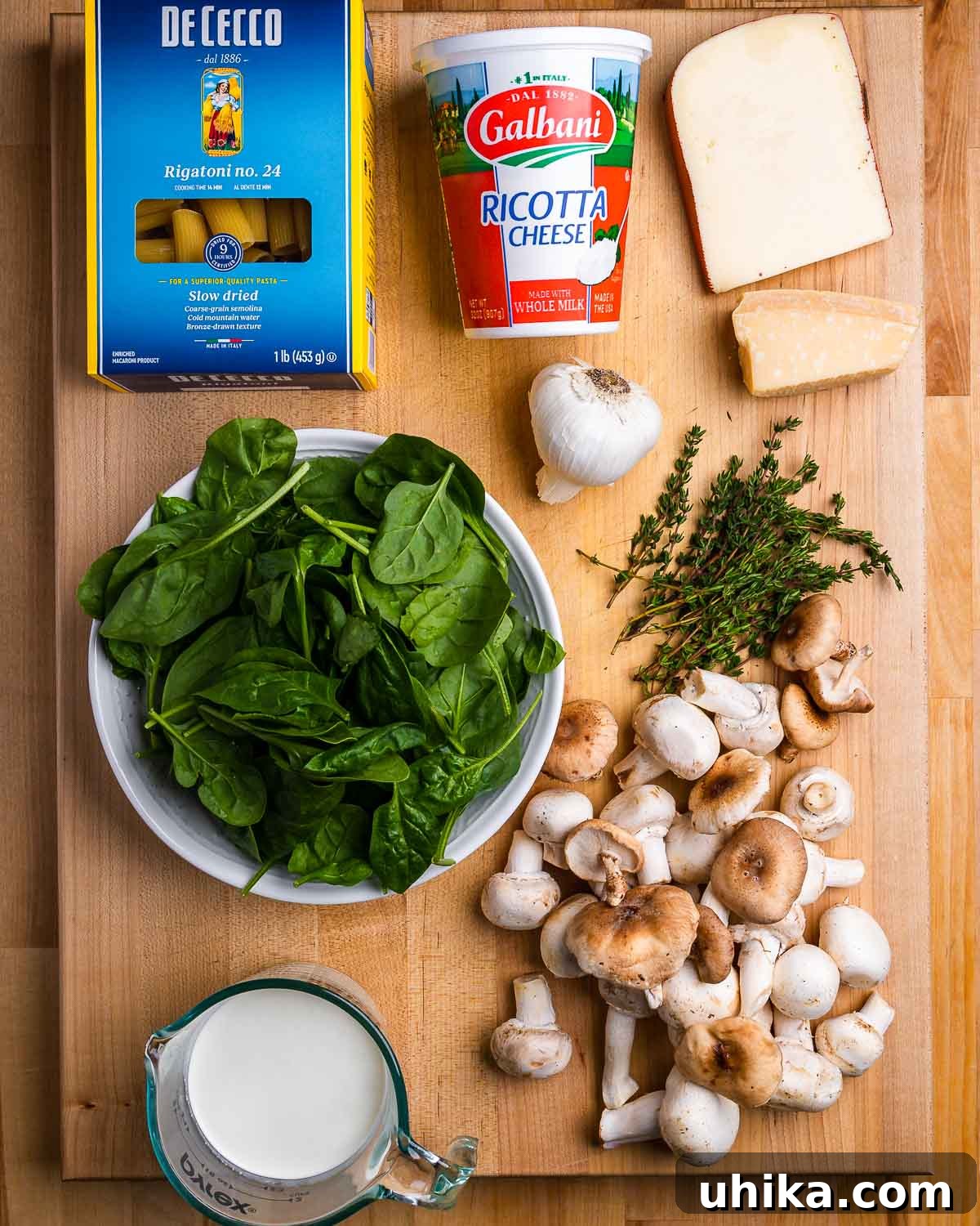 Golden Mushroom Pasta Casserole 3 Ingredients shown: rigatoni, ricotta, fontina, garlic, parmesan, spinach, thyme, mushrooms, and cream.