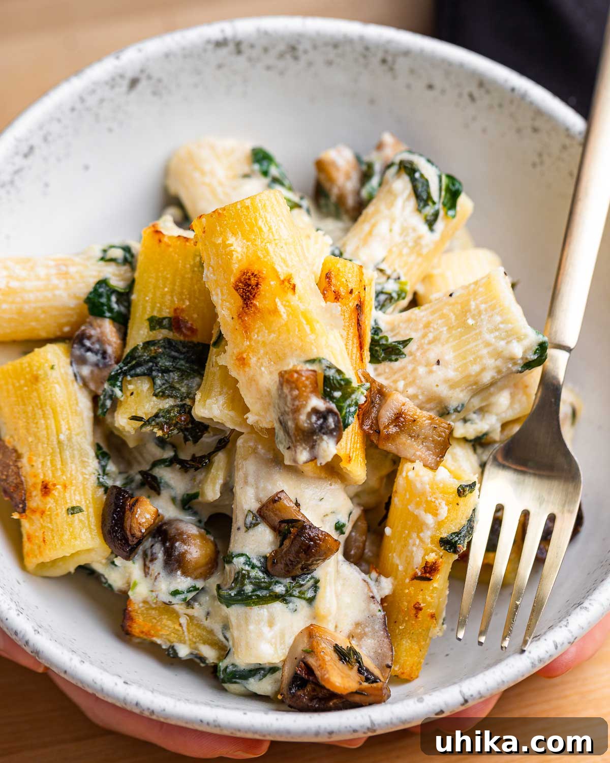 Golden Mushroom Pasta Casserole 10 White bowl with baked pasta with mushrooms and spinach.