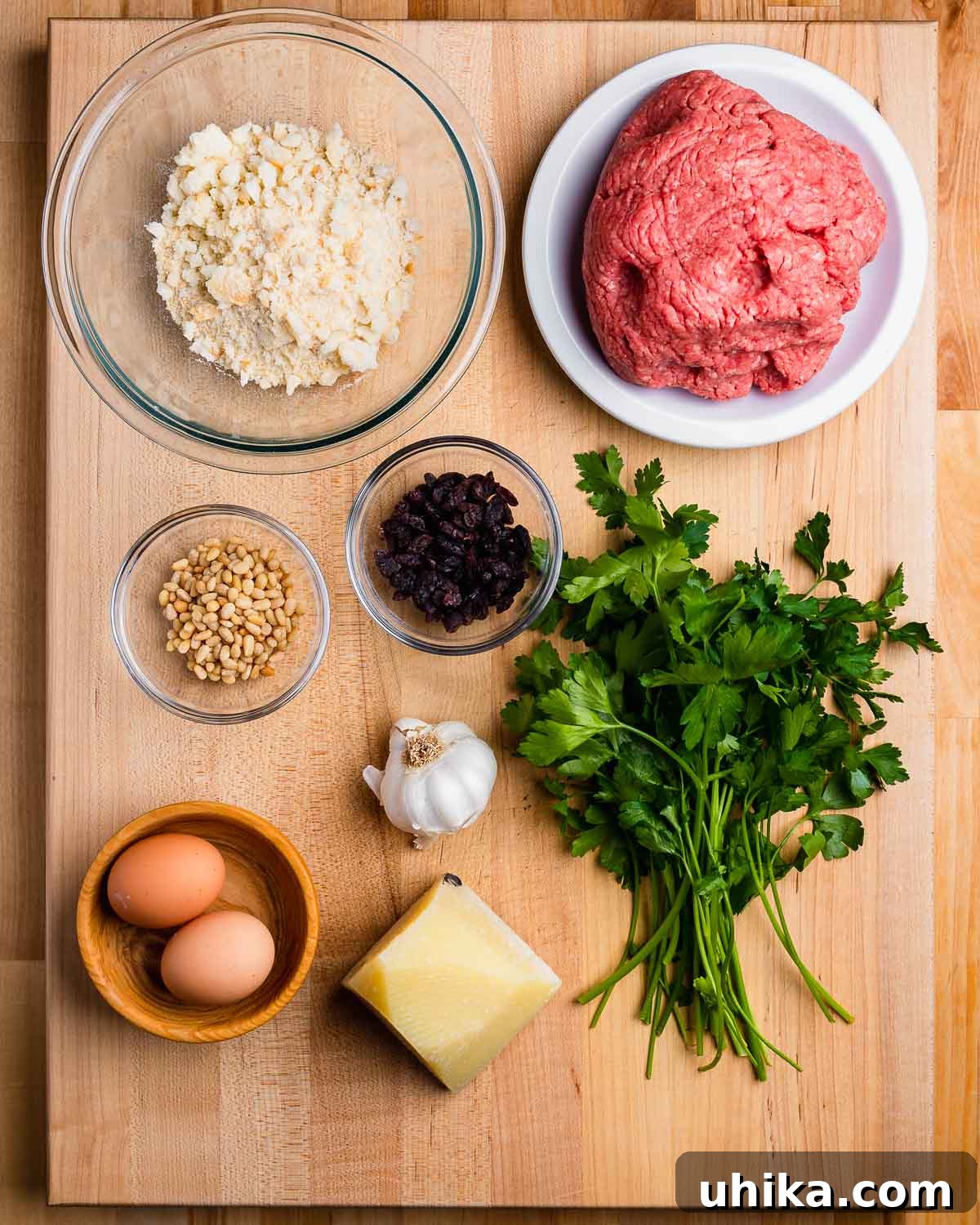 Mama's Sicilian Meatballs 3 Ingredients shown: Breadcrumbs, ground beef, pine nuts, raisins, parsley, garlic, eggs, and Pecorino.