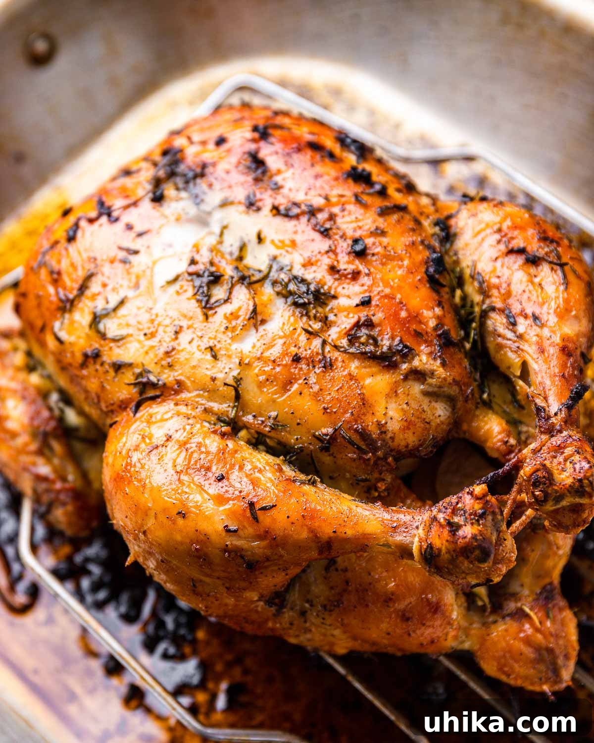 Golden Garlic Butter Roast Chicken 2 Garlic butter roast chicken in roasting pan, golden brown and garnished with fresh herbs.
