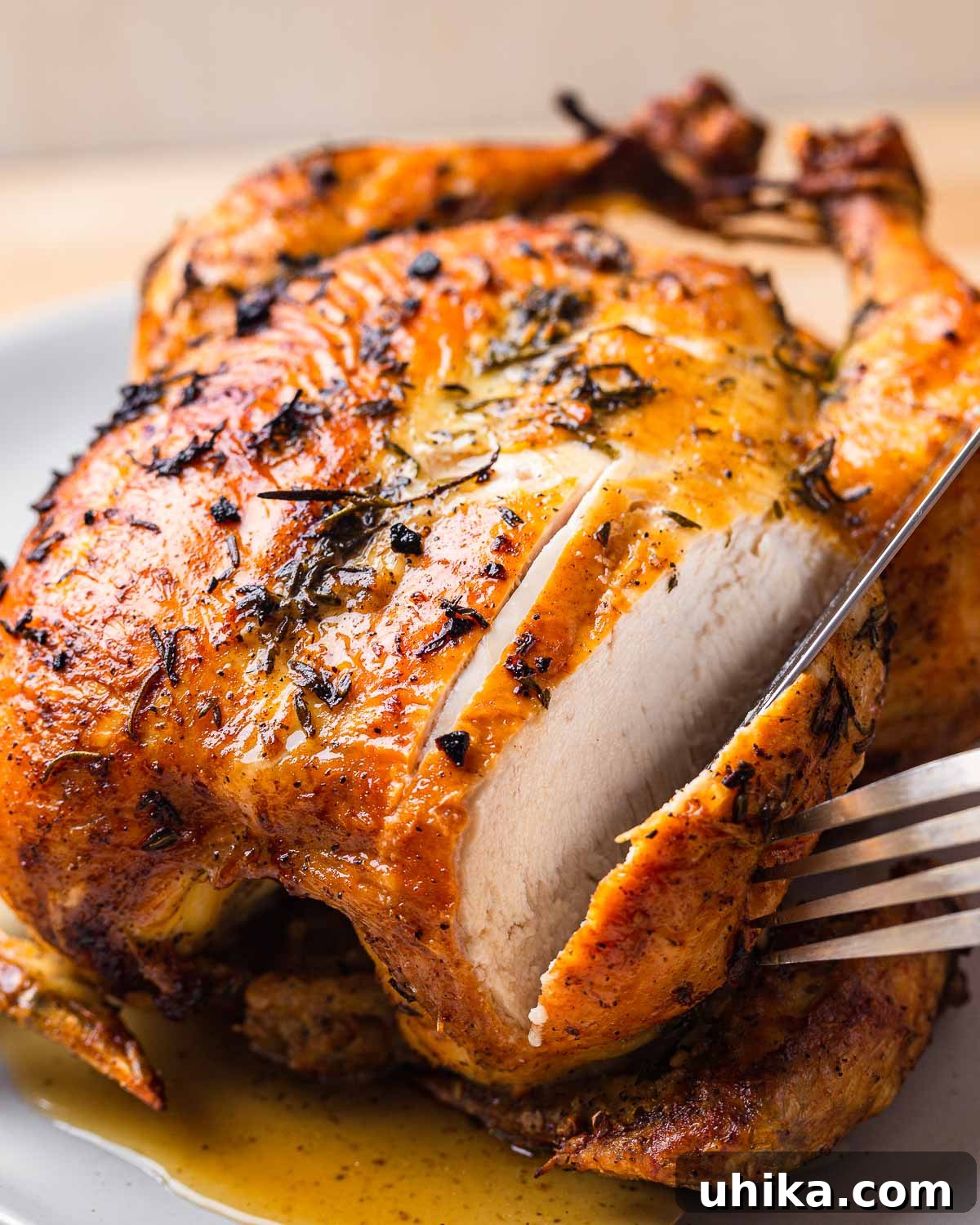 Golden Garlic Butter Roast Chicken 8 Roast chicken being expertly sliced with fork and knife, revealing juicy meat.