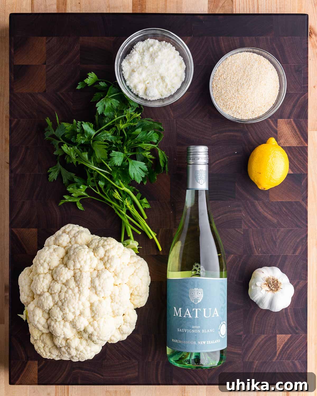 Golden Cauliflower Gratin 3 Ingredients for baked cauliflower with cheese and breadcrumbs: Pecorino cheese, breadcrumbs, parsley, cauliflower, white wine, lemon, and garlic.