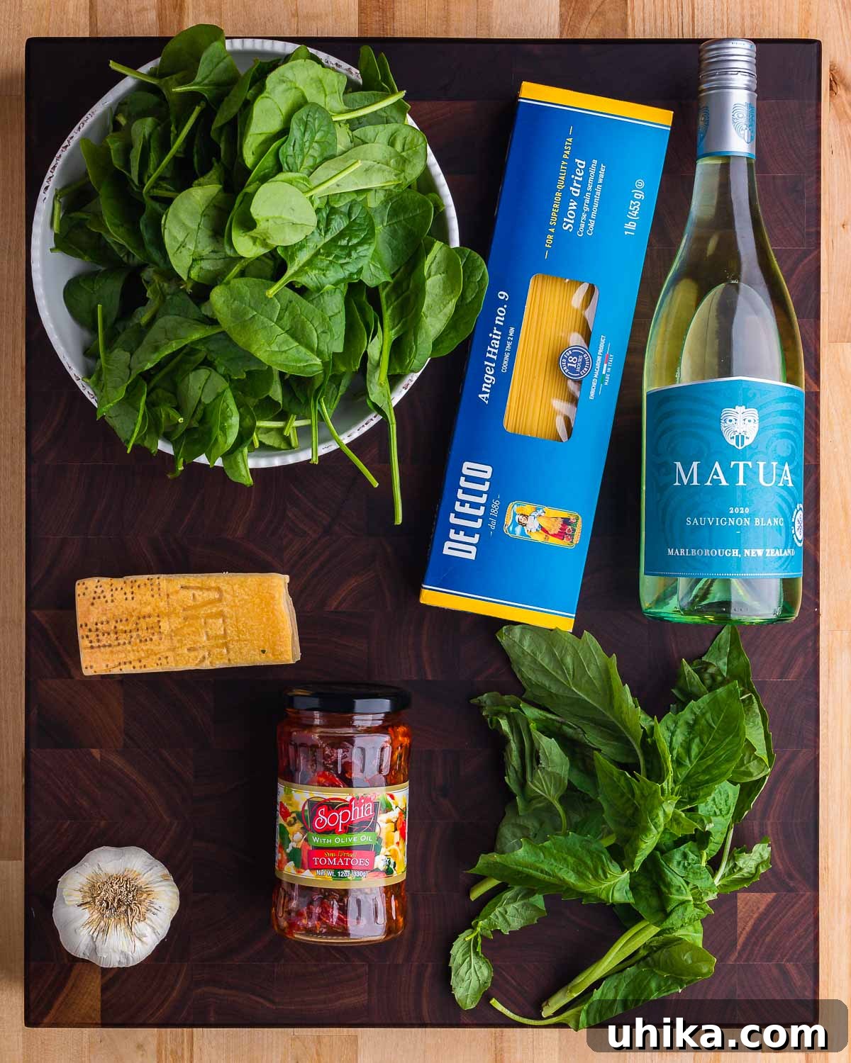 Sun-Drenched Spinach and Tomato Pasta 3 Ingredients for spinach sun dried tomato pasta: spinach, angel hair pasta, white wine, Parmigiano Reggiano, sun dried tomatoes, garlic, and basil.
