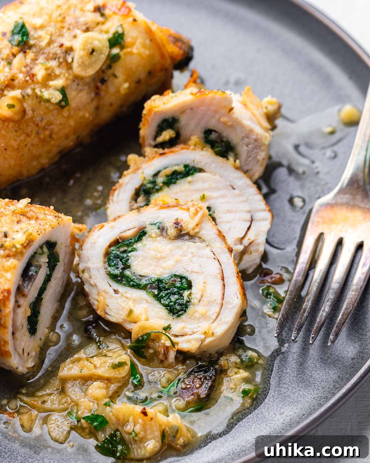 Stuffed Chicken Roulades 10 Grey plate with perfectly sliced chicken involtini, revealing the rich, cheesy filling.
