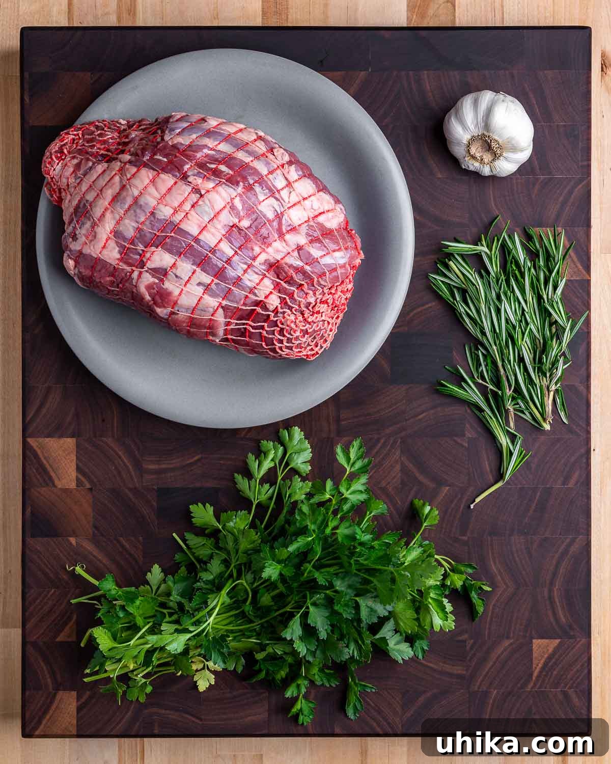 Garlic Rosemary Roasted Lamb Leg 3 Ingredients shown: boneless leg of lamb, garlic, rosemary, and parsley.
