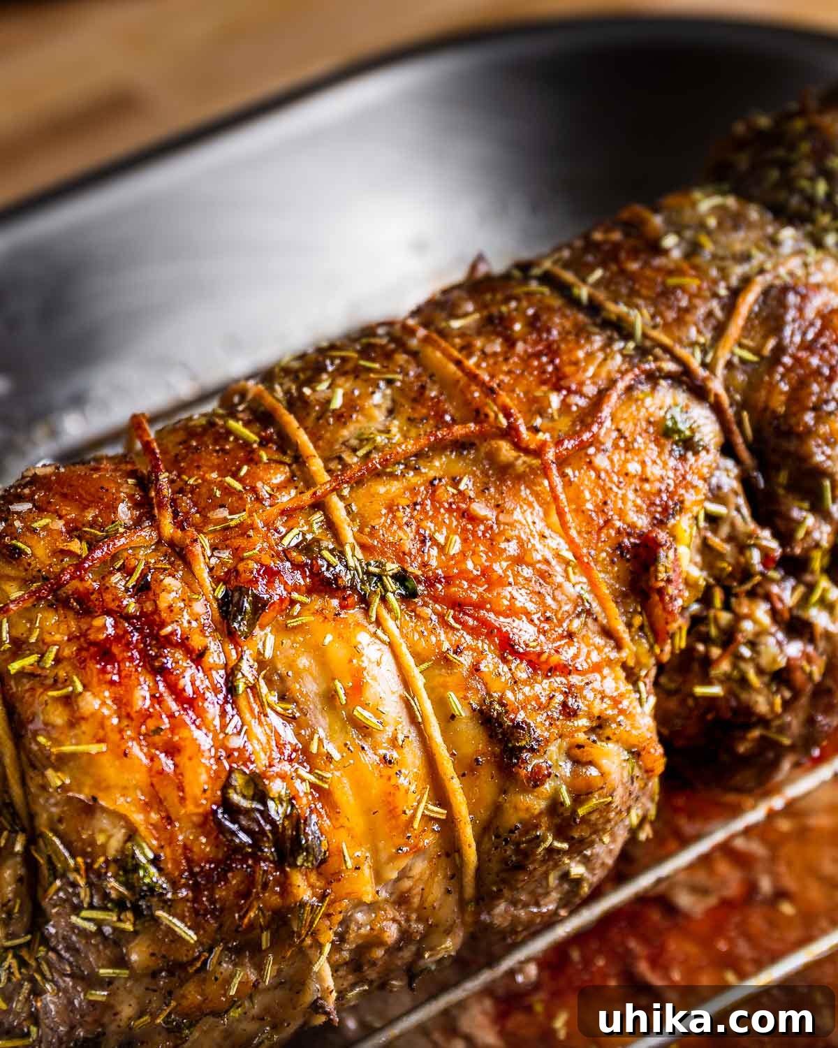 Garlic Rosemary Roasted Lamb Leg 9 Cooked boneless leg of lamb on wire rack in roasting pan.