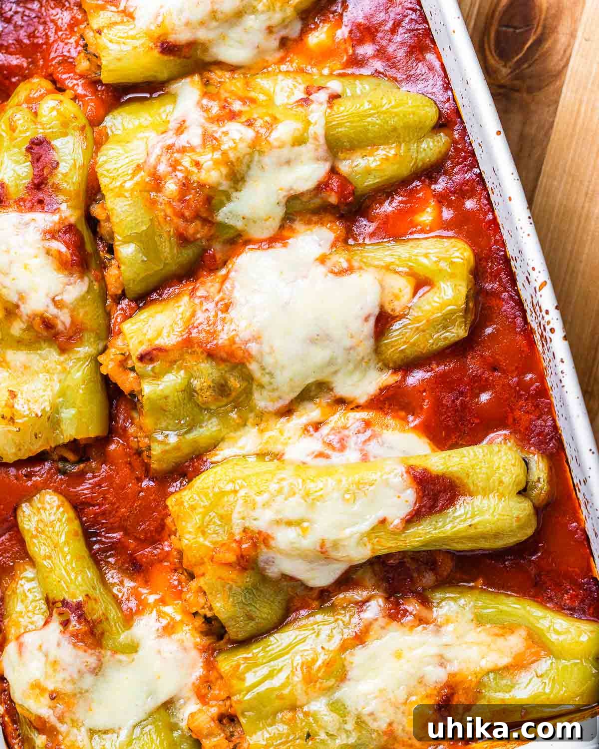 Cubanelle Comfort Boats 2 White baking dish with cooked, golden-brown Italian stuffed cubanelle peppers, ready to serve.