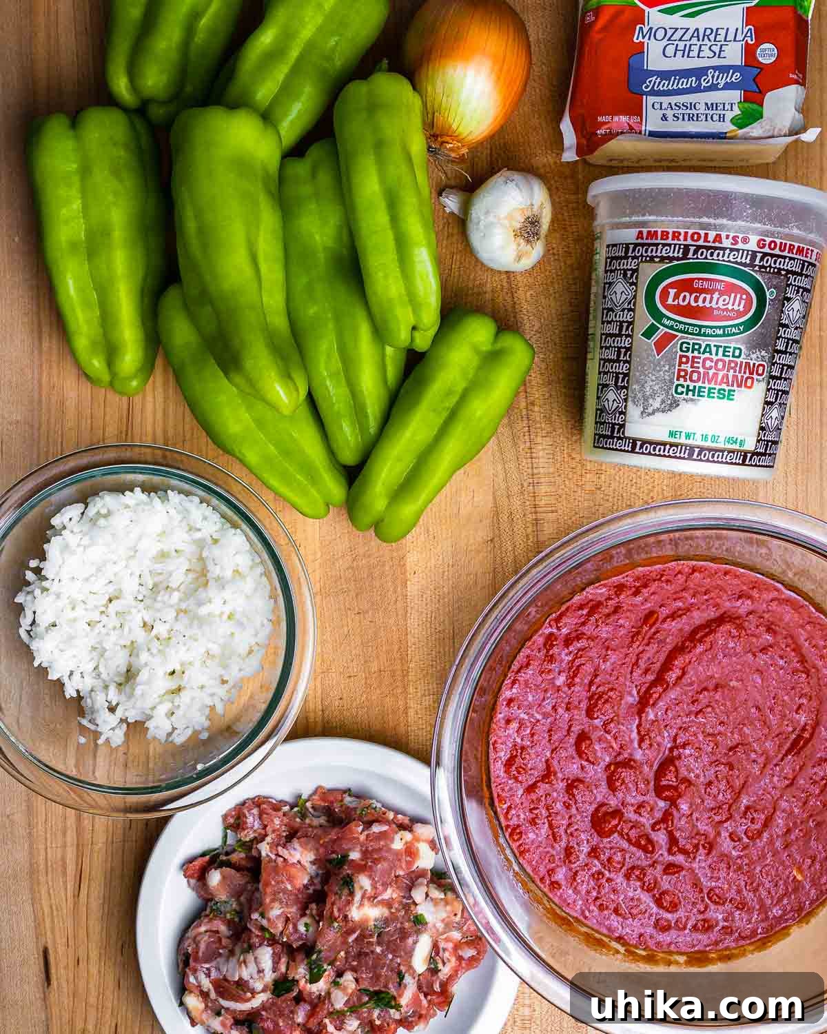 Cubanelle Comfort Boats 3 A vibrant display of fresh ingredients for Italian stuffed cubanelle peppers, including peppers, onion, garlic, mozzarella, Pecorino Romano cheese, rice, ground sausage, and tomato sauce.