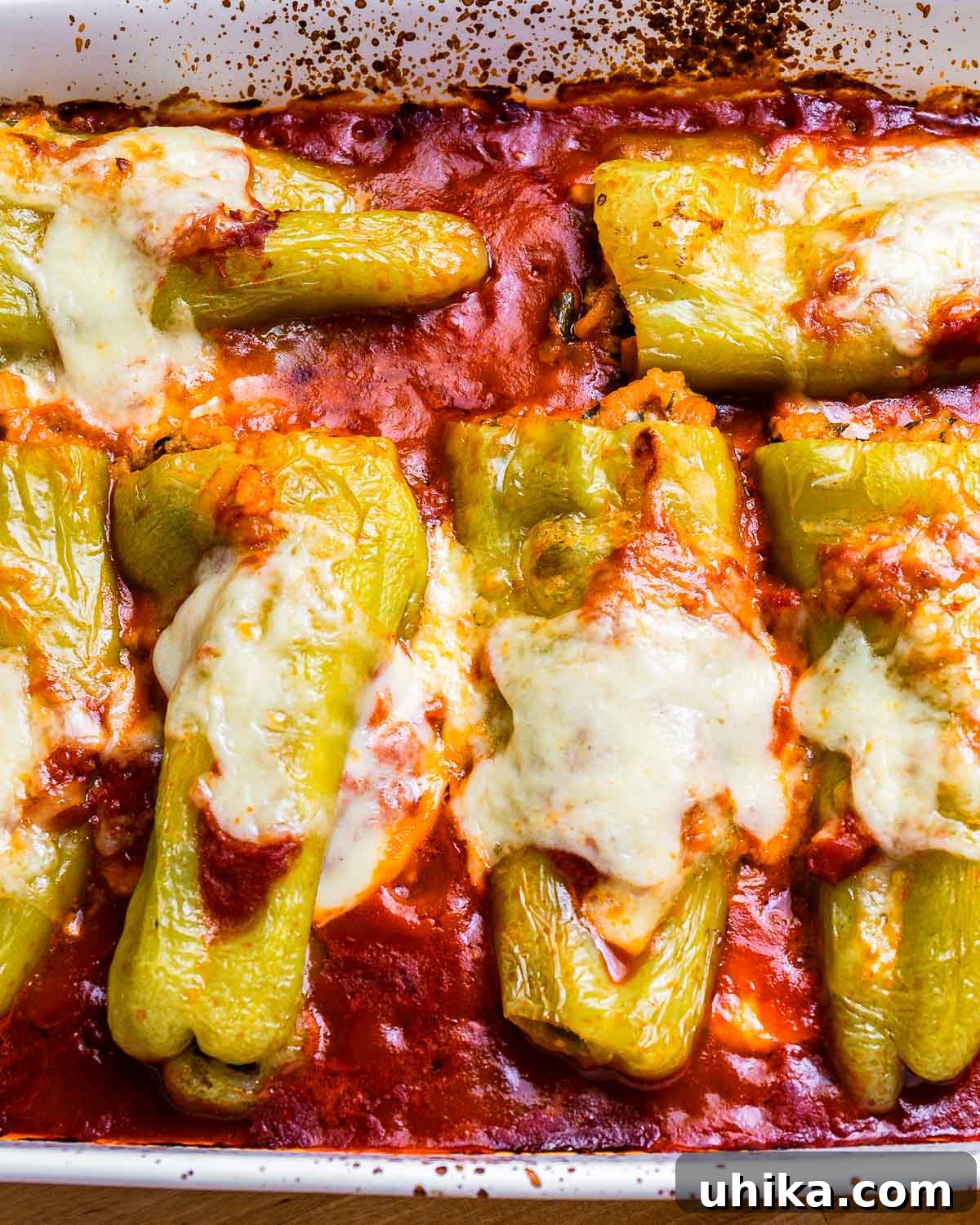 Cubanelle Comfort Boats 8 Close-up of perfectly cooked Italian stuffed cubanelle peppers in a baking dish, with melted cheese and rich marinara sauce.