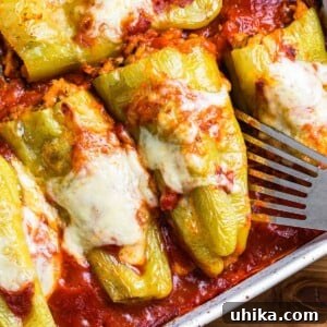 Cubanelle Comfort Boats 9 Close-up of a single cooked Italian stuffed cubanelle pepper with melted cheese and sauce.