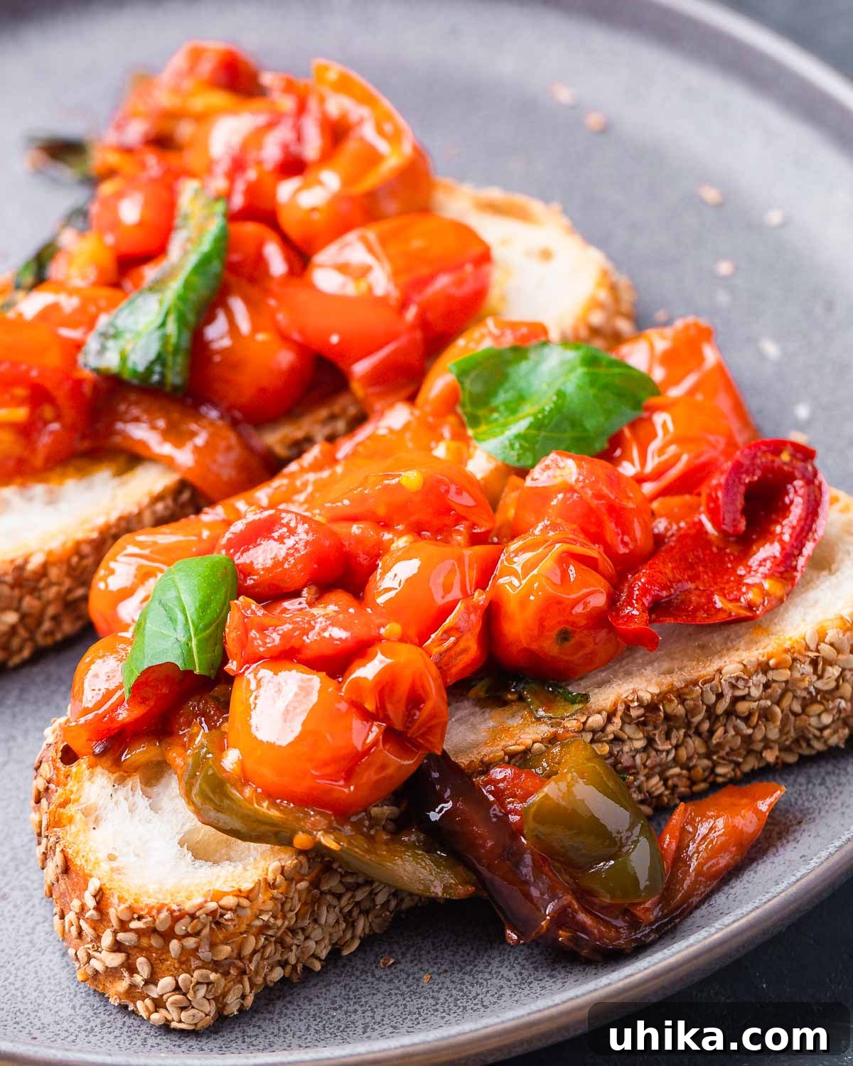 Zesty Cherry Pepper Preserve 2 Cherry pepper spread on toasted bread pieces in grey plate, highlighting its vibrant color and inviting texture.