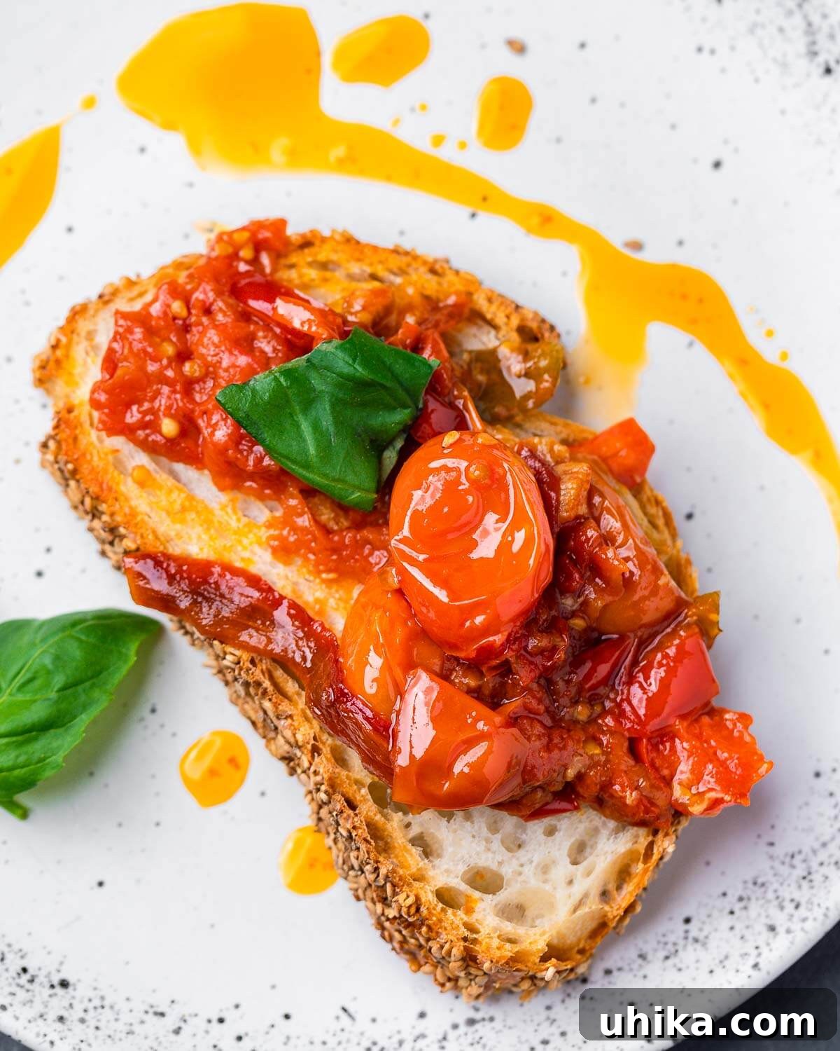 Zesty Cherry Pepper Preserve 8 Generous serving of cherry pepper spread on toasted Italian bread in a white plate, garnished with fresh basil.