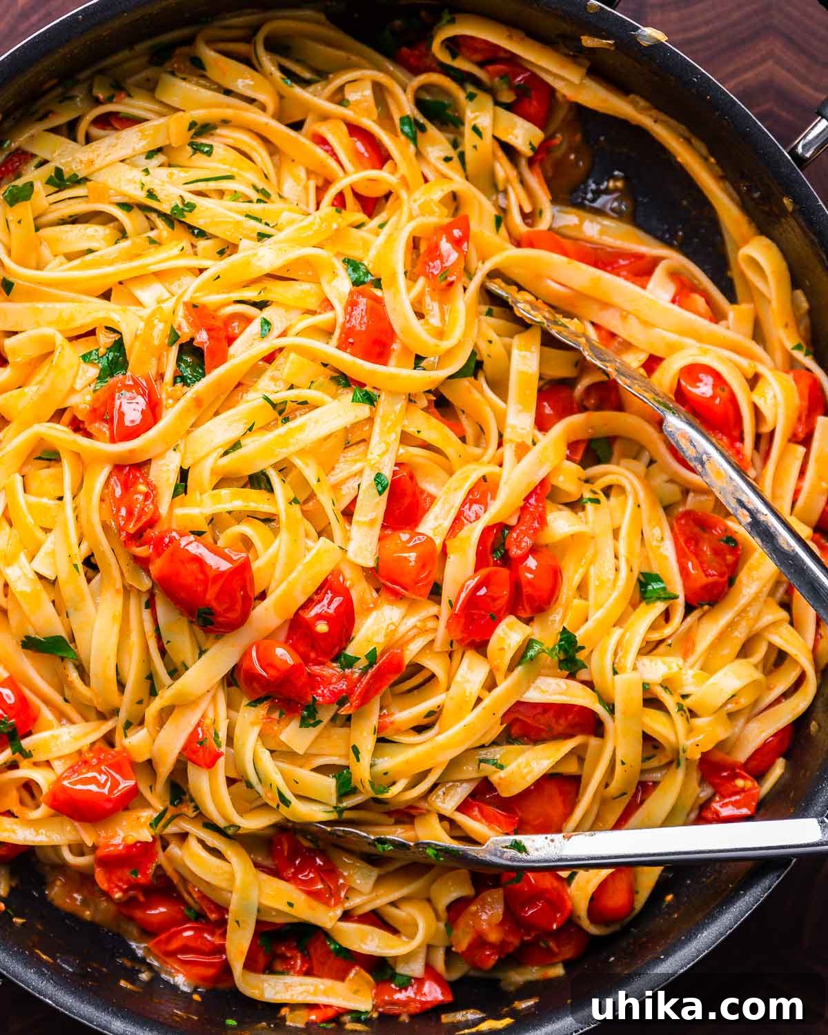 Blushing Cherry Tomato Butter Fettuccine 9 Fettuccine with cherry tomato butter sauce in a black pan, showing the rich texture of the sauce.