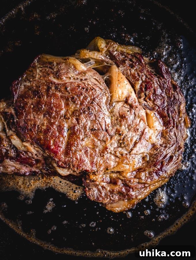 Reverse Seared Ribeye Steaks - sipandfeast.com #reversesear #ribeye #steak #dinner Cooking ribeye steak in cast iron pan.