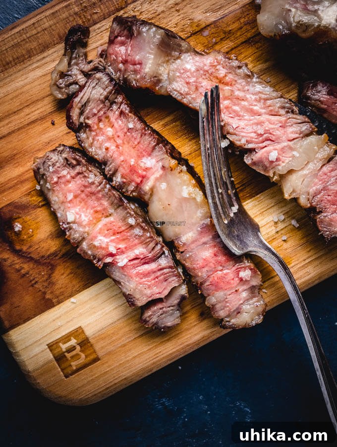 Reverse Seared Ribeye Steaks - sipandfeast.com #reversesear #ribeye #steak #dinner Medium rare sliced ribeye steak.