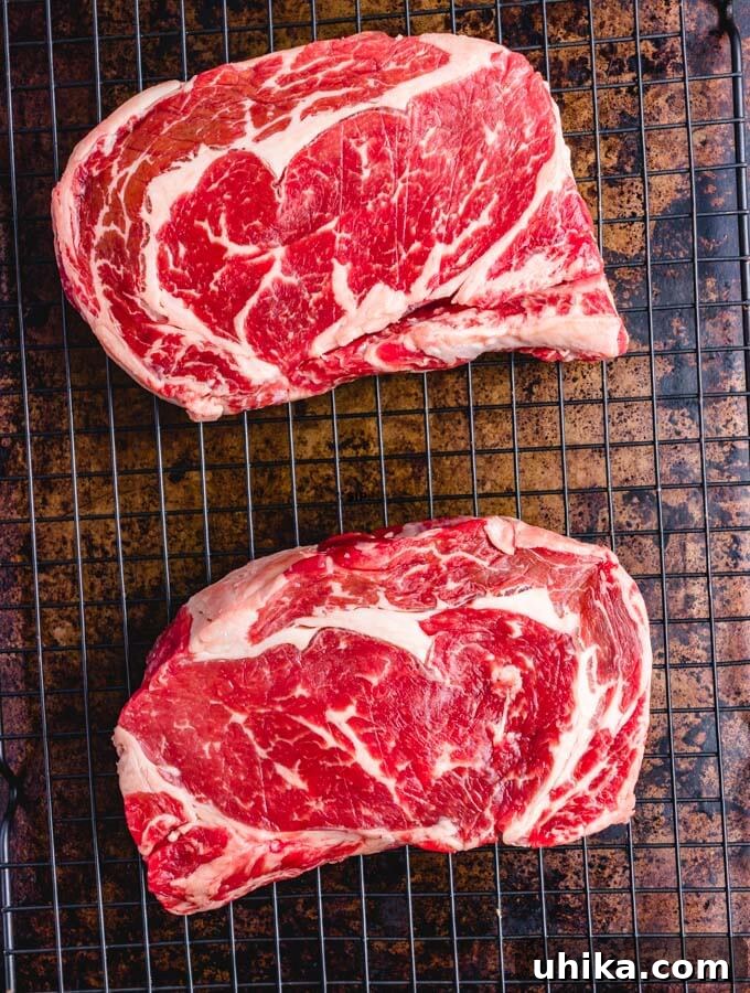 Reverse Seared Ribeye Steaks - sipandfeast.com #reversesear #ribeye #steak #dinner Raw ribeyes on wire rack.