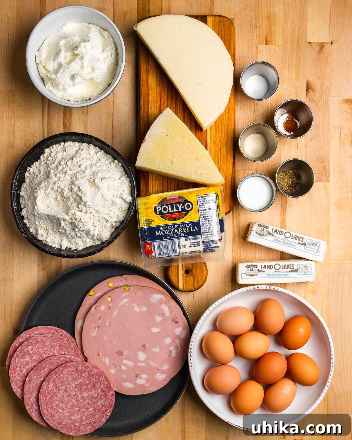 Rustic Italian Easter Feast Pie 3 Ingredients shown: cheeses, flour, seasonings, butter, cold cuts, and eggs.