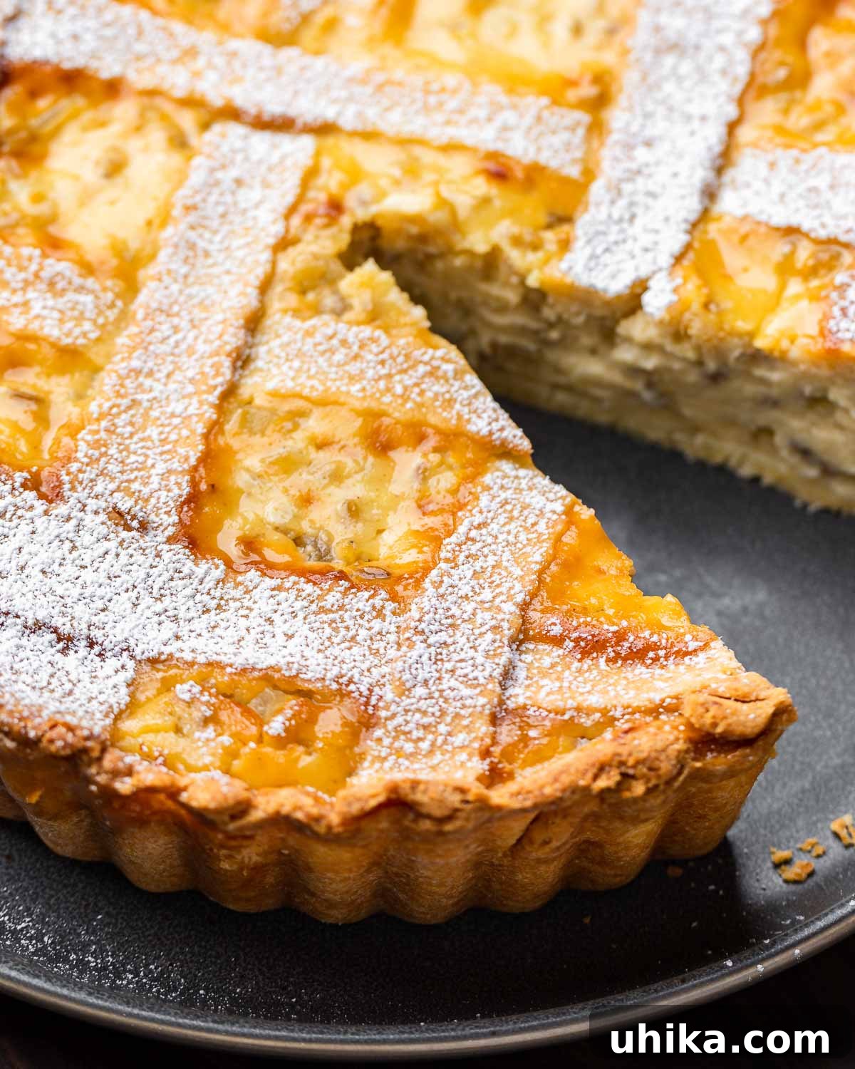 Naples' Signature Easter Dessert 2 Pastiera Napoletana pie with slice removed in grey plate.
