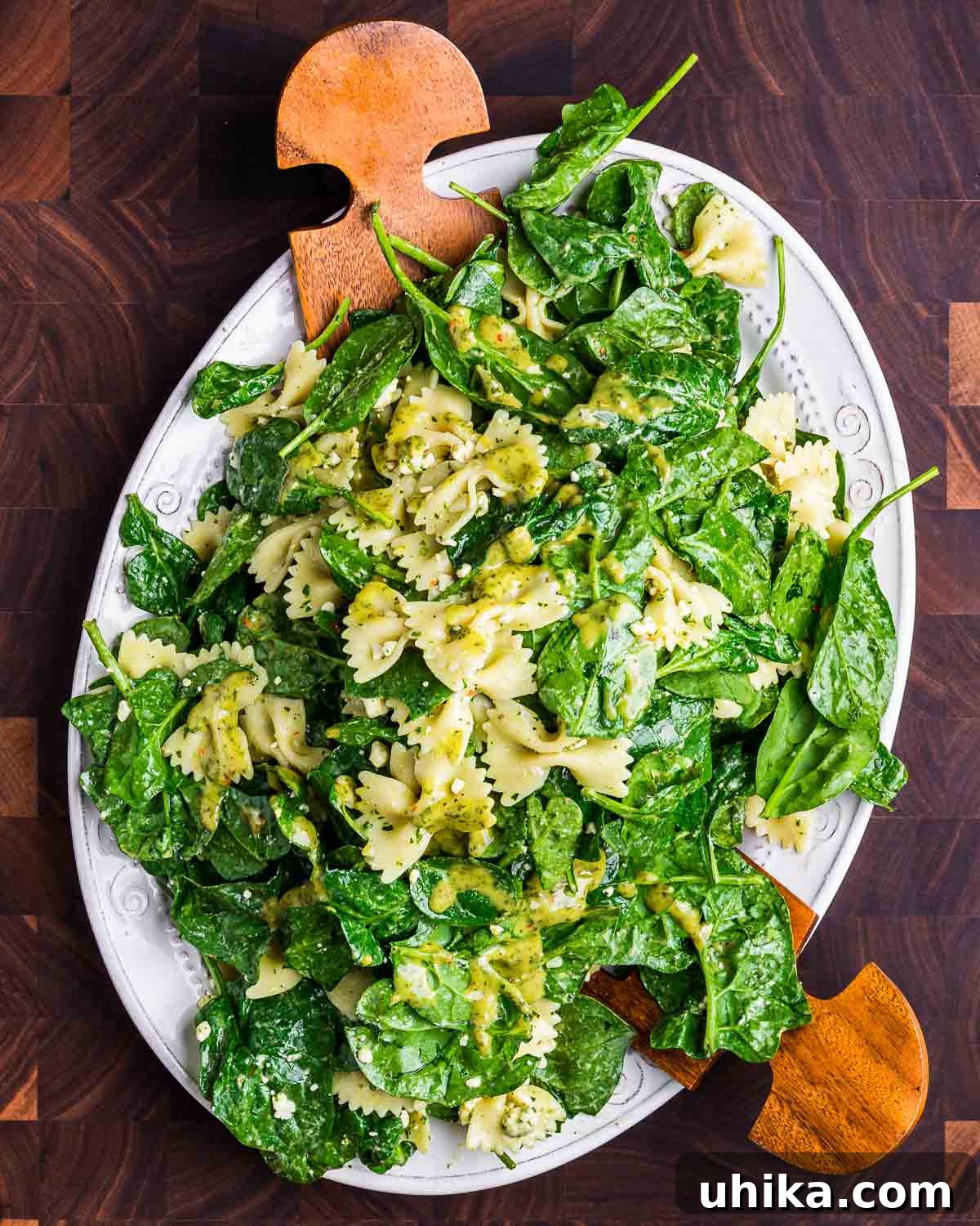 Creamy Gorgonzola & Spinach Pasta Salad 6 Spinach Gorgonzola Pasta Salad elegantly arranged on a white platter, placed on a wooden cutting board.