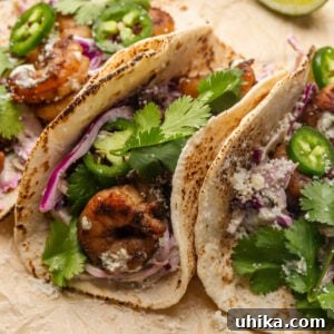 Spicy shrimp tacos with cilantro garnish on parchment paper.