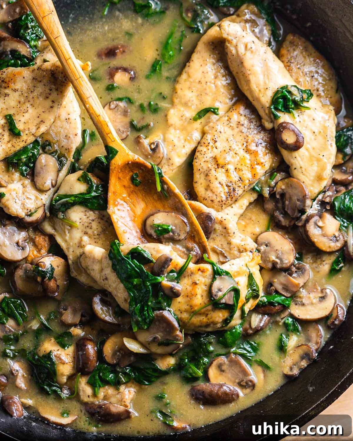 Chicken with Spinach and Mushroom Medley 2 Golden brown spinach mushroom chicken served directly in a cast iron pan, ready to eat.