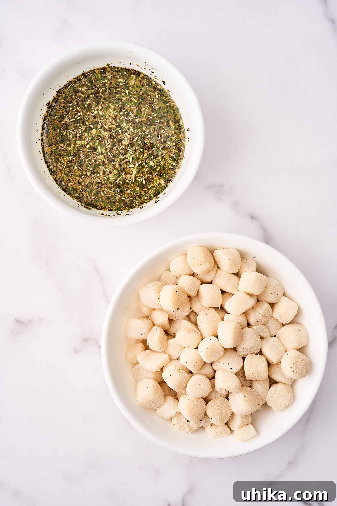 Sun-Kissed Sicilian Bay Scallop Pasta 4 Two small mixing bowls, one filled with bay scallops dusted in seasoned flour, and the other with fresh thyme, rosemary, and oregano for the sauce.