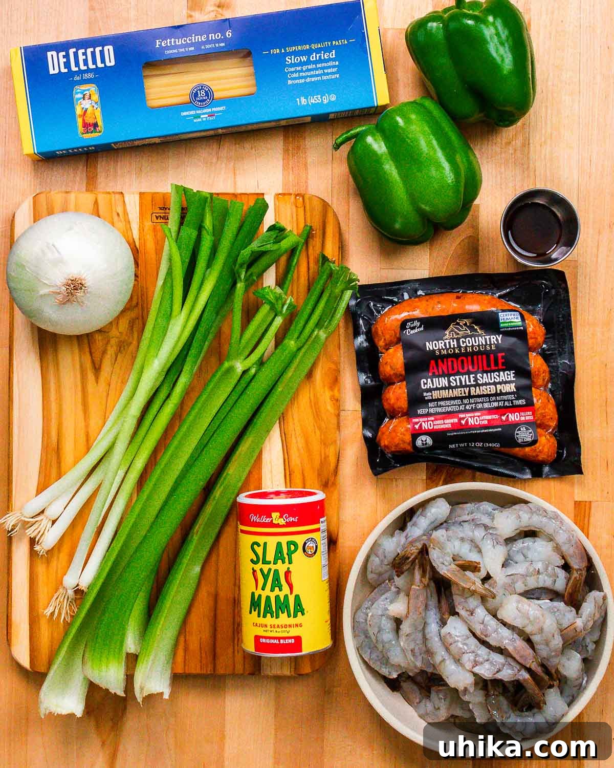 Bayou Shrimp and Sausage Pasta 3 Ingredients for Cajun shrimp and sausage pasta shown: pasta, bell peppers, onion, green onions, celery, Worcestershire sauce, Andouille sausage, Cajun seasoning, and shrimp.