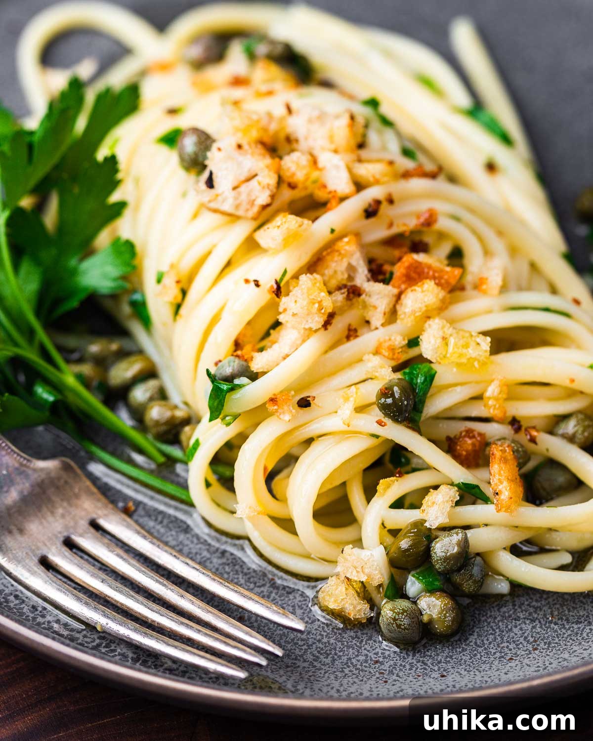 Zesty Lemon Caper Pasta 2 Lemon caper pasta in grey plate with fork.