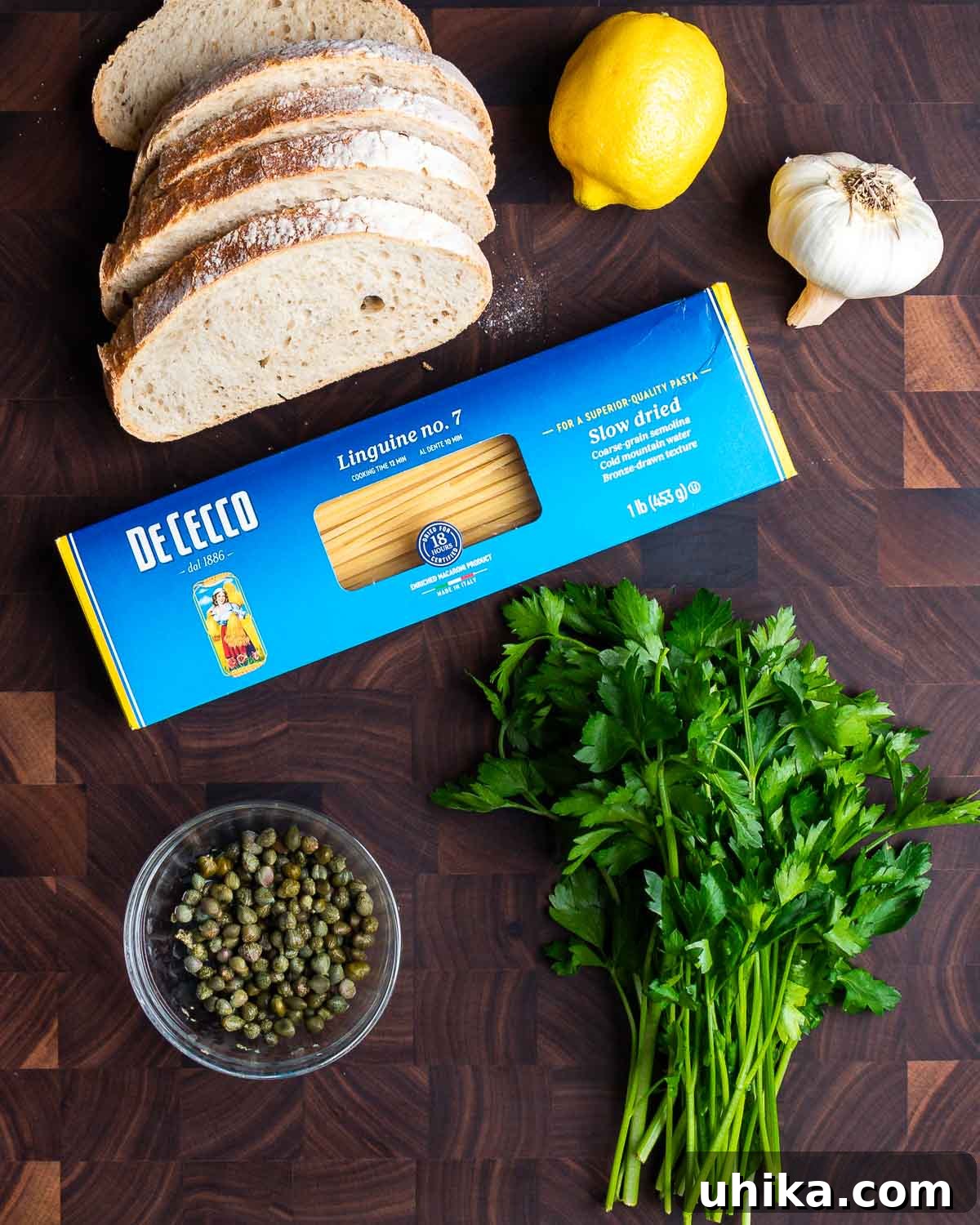 Zesty Lemon Caper Pasta 3 Ingredients shown: bread, lemon, garlic, linguine, capers, and parsley.