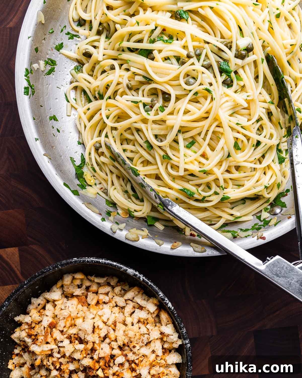 Zesty Lemon Caper Pasta 9 Overhead shot lemon caper linguine in pan and bowl of breadcrumbs.