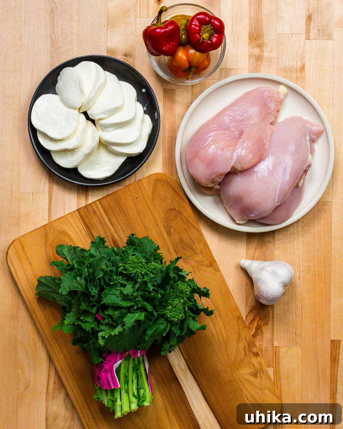 Pan-Seared Chicken with Garlicky Broccoli Rabe 3 Ingredients shown: mozzarella, cherry peppers, chicken breasts, broccoli rabe, and garlic.
