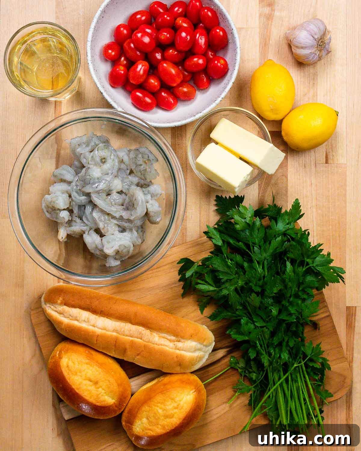 A vibrant display of fresh ingredients for shrimp scampi rolls, including white wine, ripe tomatoes, fragrant garlic, zesty lemon, rich butter, plump shrimp, crusty rolls, and fresh parsley.