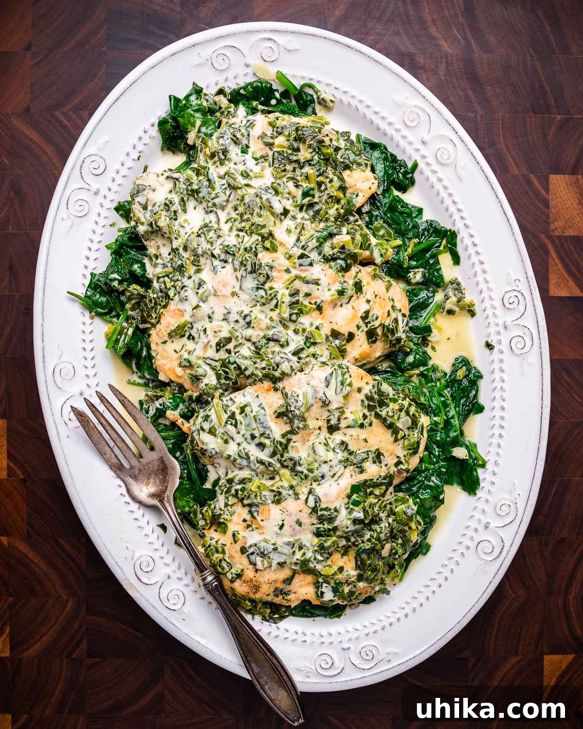 Creamy Tuscan Chicken 8 Close-up of finished Chicken Florentine in a serving platter on a walnut cutting board.