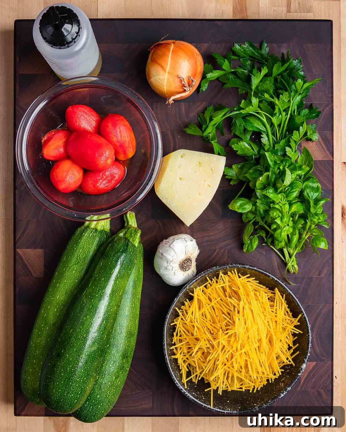 Nonna's Zucchini Soup 3 Ingredients for Italian zucchini soup: olive oil, plum tomatoes, onion, Pecorino, parsley, basil, garlic, zucchini, and broken spaghetti.