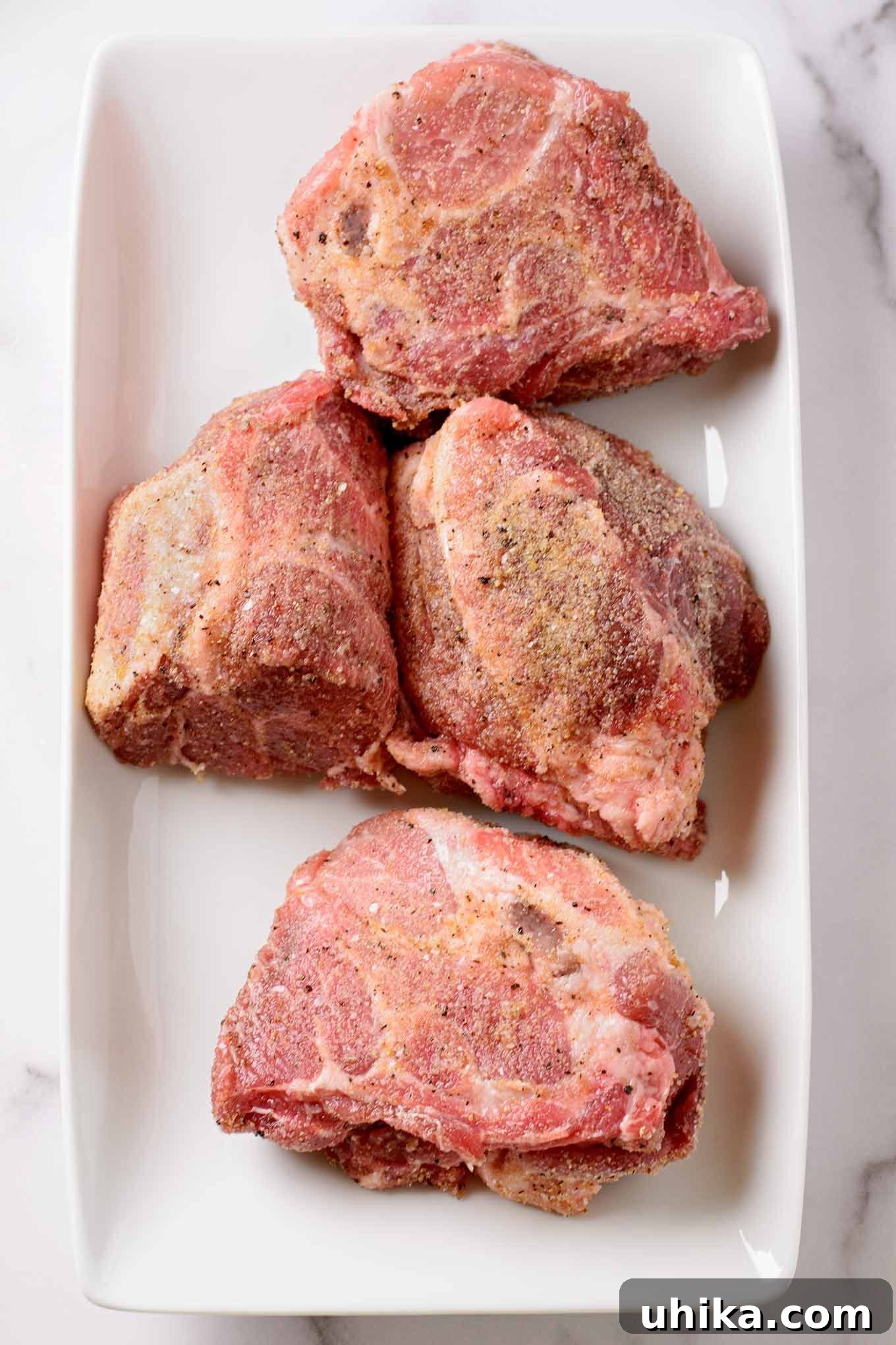 Fall-Apart Tender Oven Pulled Pork 3 A Boston butt pork roast trimmed of excess fat, seasoned, and cut into quarters for faster, more even cooking.