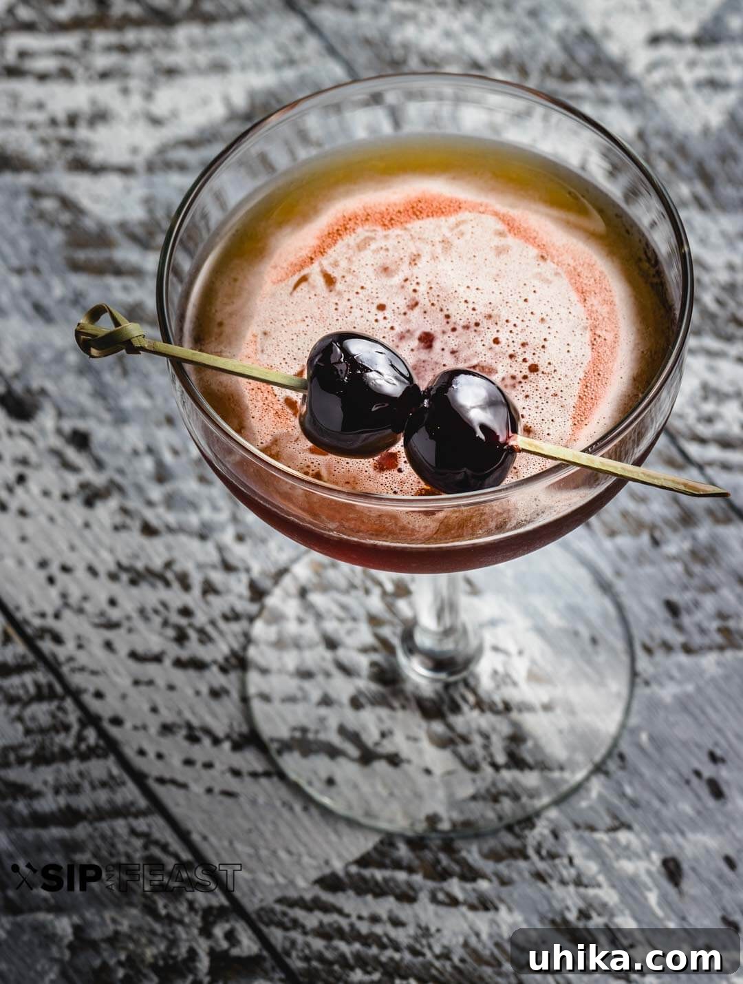 Perfect Manhattan Recipe - sipandfeast.com #manhattan #cocktails #amarenacherries #rye A perfectly chilled glass of Manhattan cocktail garnished with two glistening Amarena cherries on a skewer, ready to be enjoyed.