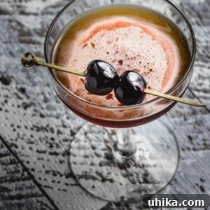 Perfect Manhattan Recipe featured image, showcasing the cocktail in a glass with cherries.