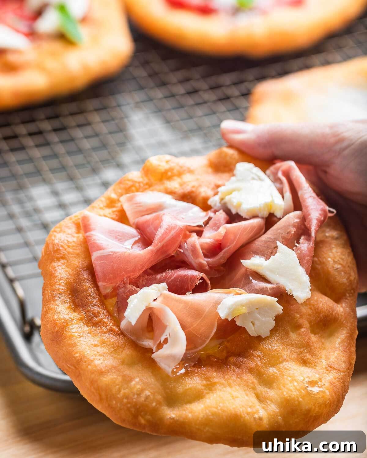 Golden Fried Pizza 8 Hands holding pizza fritta with prosciutto and fresh mozzarella.