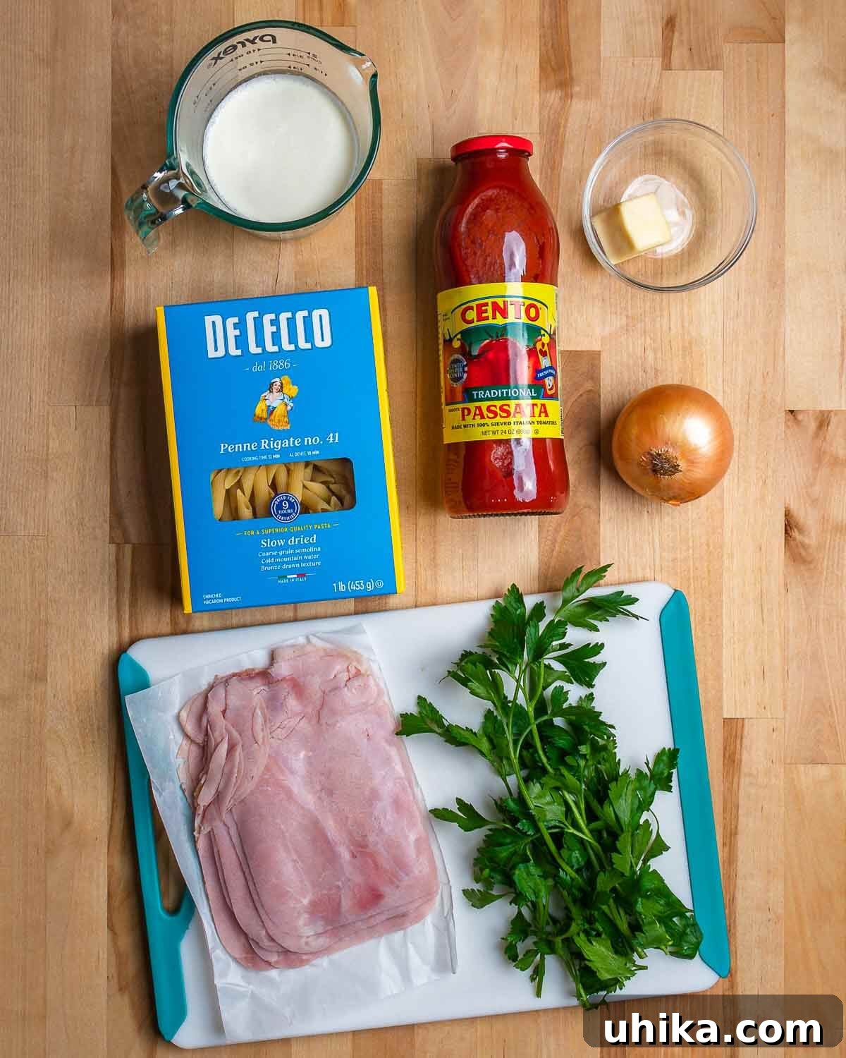Ingredients for Penne al Baffo: heavy cream, penne pasta, passata, butter, onion, deli ham, and fresh parsley.