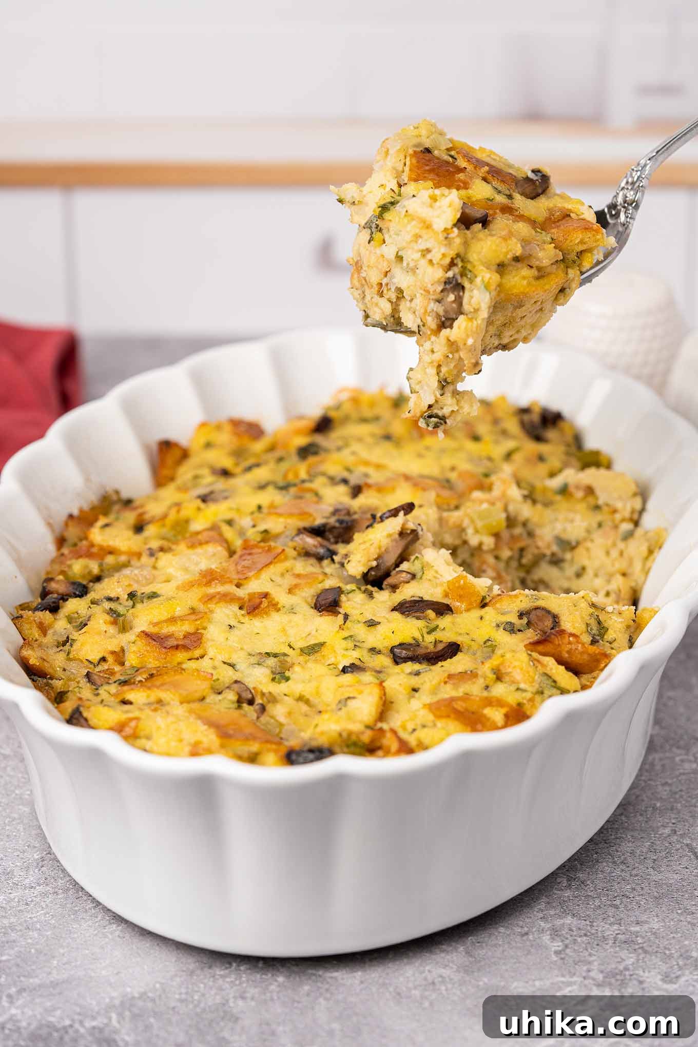 Heirloom Bread Stuffing 7 A casserole of traditional bread stuffing with a spoonful being removed for serving showing its moist, fluffy texture.