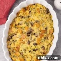 An oval casserole dish filled with old-fashioned bread stuffing made with sourdough bread, celery, onions, and mushrooms.