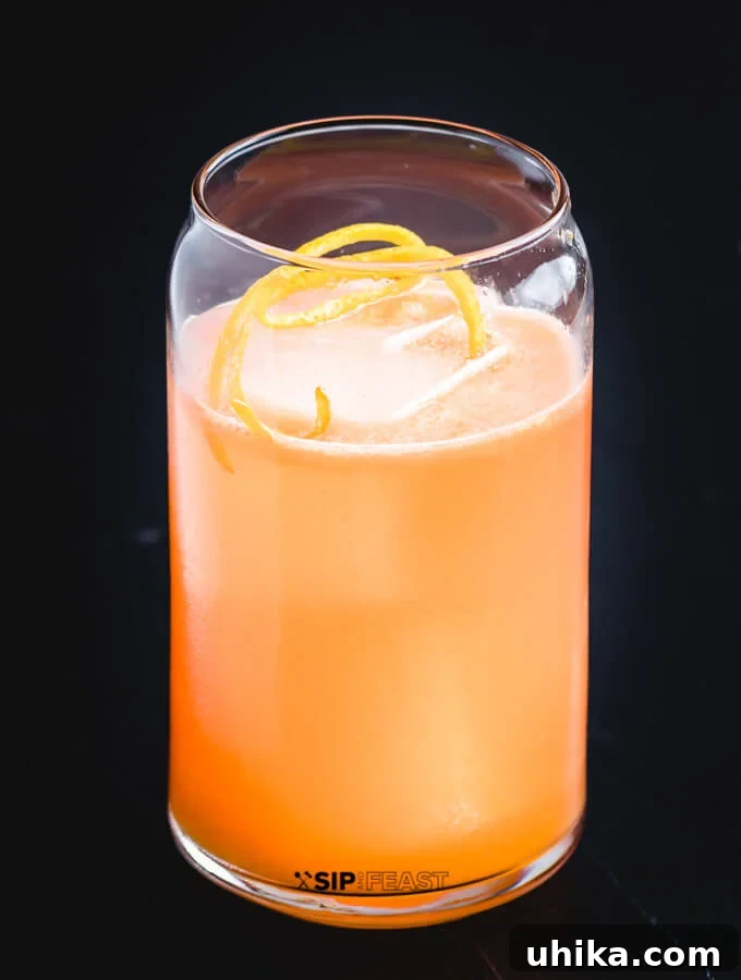 Campari Kissed Tequila Orange Margarita 2 A glass with the Italian Margarita, Ice and Orange peel.