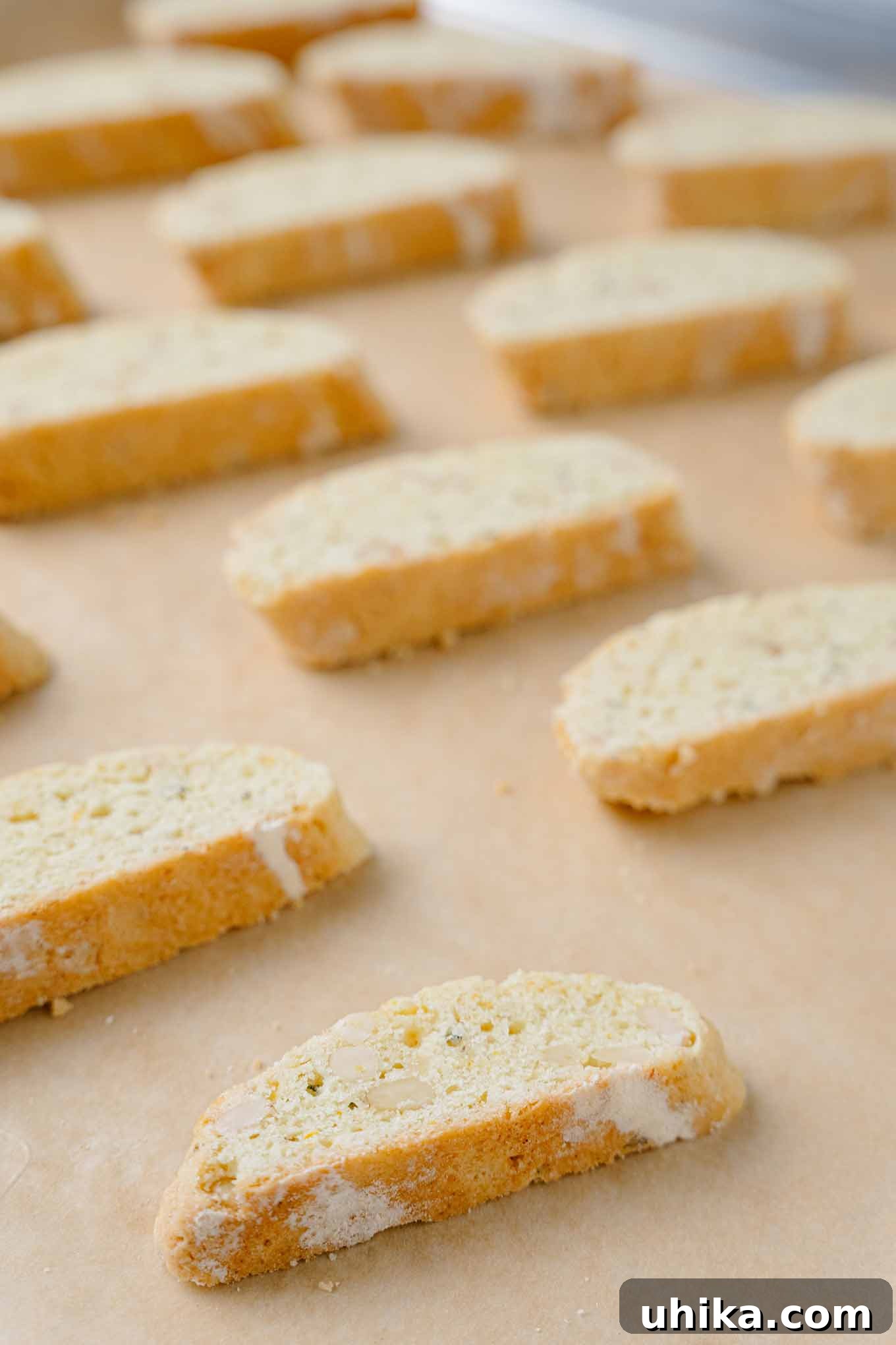 Zesty Butter Biscotti: A Double Treat 5 A close-up view of perfectly sliced orange biscotti arranged on a baking sheet, prepared for the second baking cycle.